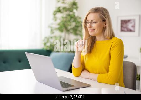 Pensive woman using laptop Stock Photo
