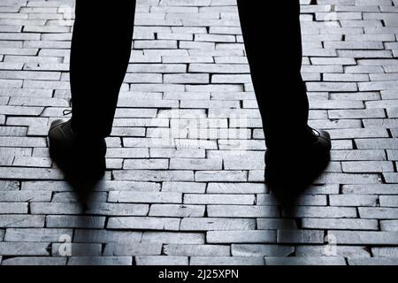 Silhouette of man waiting. Close-up on legs ans shoes. Stock Photo