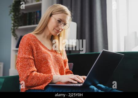 Woman with laptop on couch Stock Photo