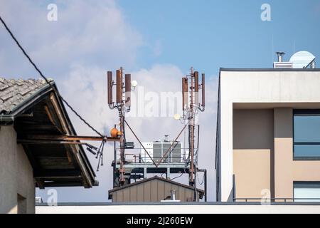 Mobile phone and internet cell tower over against sky. 5G wireless radiation antennas. Stock Photo