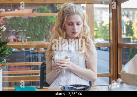 Serious young woman with an aromatic coffee in her hands Stock Photo