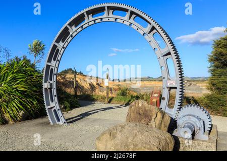 A giant cogwheel, once used for crushing ore, used as an archway at the Martha gold mine, Waihi, New Zealand Stock Photo