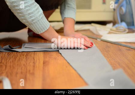 Top view of tailor hands working with scissor and suit textile cloth ...