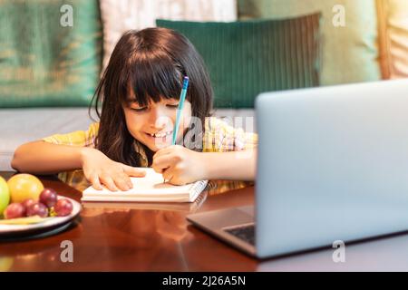 young student using laptop computer for studying online from home watching web class lesson or listening tutor by video call. distance learning Stock Photo