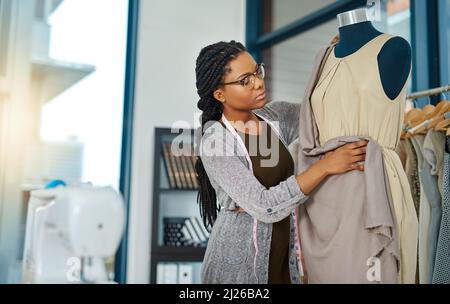 Believe in yourself and be prepared to work hard. Shot of a young woman working in her clothing boutique. Stock Photo