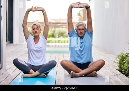 Stretch your body, stretch your mind. Shot of a mature couple exercising together outdoors. Stock Photo
