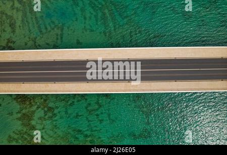Aerial top view of a long bridge above a sea Stock Photo