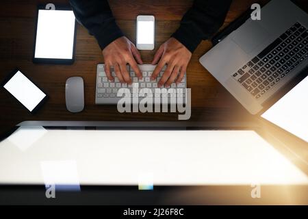Hes got some clever tactics. High angle shot of a hacker cracking a computer code in the dark. Stock Photo