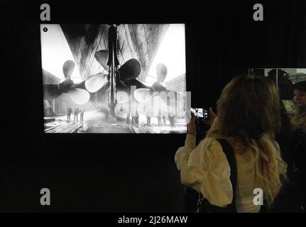 The Titanic Exhibition - visitors looking at a photograph of the Titanic ship propellers, London UK