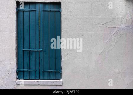 Painted blue wooden shutters and white stucco wall with negative space for copy Stock Photo