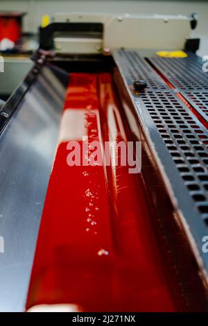 Color and glossy rollers of offset printing machine. offset ink colour.  Magenta. Photo taken vertically, front side of photo with selected focus. Stock Photo