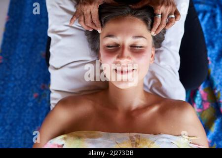 This is the most pleasant and relaxing massage Ive had. High angle shot of a young woman getting a relaxing massage at the spa. Stock Photo