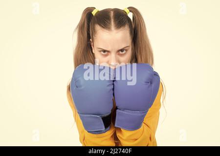 concentrated kid punching. fist to fight. teen girl in boxing gloves. angry attack. Stock Photo