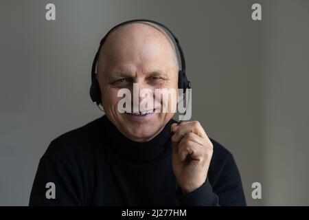 Positive aged grey-haired businessman in glasses sit at desk looking at camera, webcam view. lead online course old entrepreneur and virtual Stock Photo