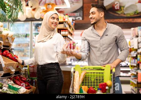 Middle Eastern Spouses Doing Grocery Shopping Buying Vegetables In Supermarket Stock Photo