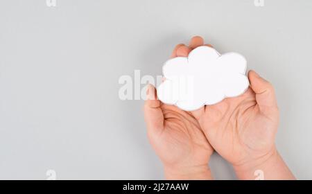 Holding a white cloud in the hand, empty copy space for text, gray background, communication and marketing concept, being connected, networking Stock Photo