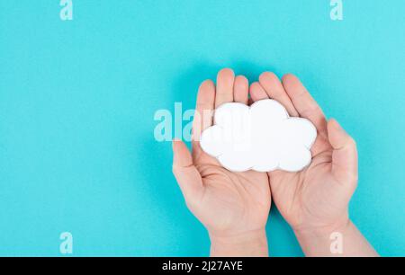 Holding a white cloud in the hand, empty copy space for text, blue background, communication and marketing concept, being connected, networking Stock Photo