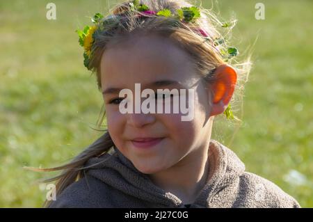 young smiling girl in a meadow wearing a hand made chaplet in her hair ,spring summer holiday Stock Photo