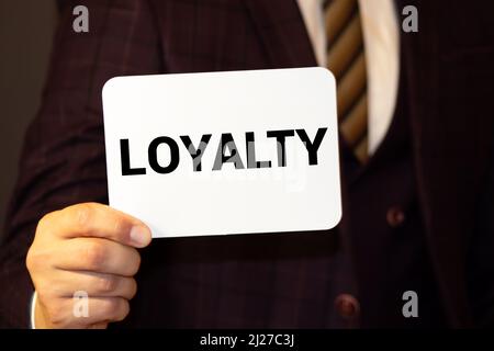 LOYALTY word on the card shown by a man. Stock Photo