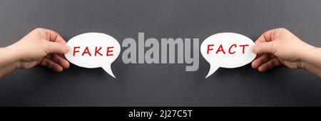 The words fact and fake are standing on a speech bubble, false and true information, media concept Stock Photo