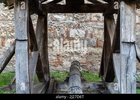 Ancient battering ram with roof cover in front of a fortress wall Stock Photo