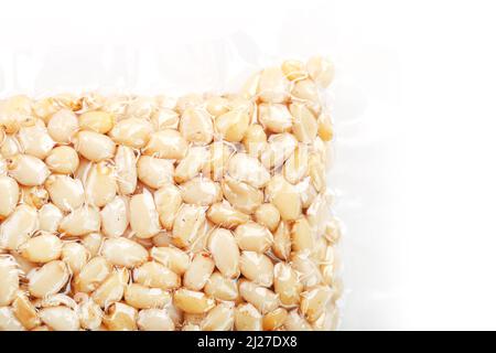 Kernels of peeled pine nuts in vacuum packaging on a white background Stock Photo