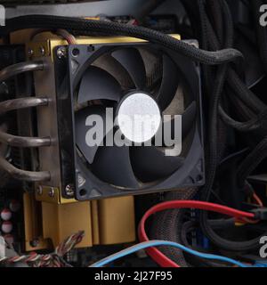 A dusty CPU fan in a computer case. Close up. Stock Photo