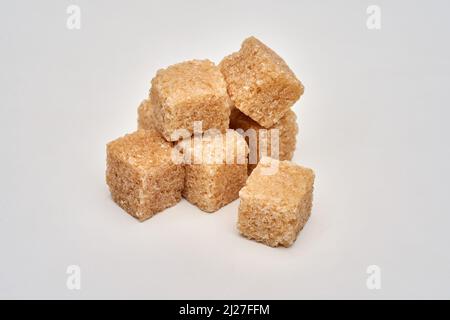 Brown sugar cubes isolated on white background, closeup shot Stock Photo