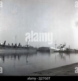 1961, historical, cargo ships moored at Birkenhead docks, Mersey, Liverpool, England including a steam barge and ship, City of Lichfield, a motor vessel built by William Denny & Bros on the Clyde for shipping company Ellerman Lines. She was launched in November 1960. Stock Photo