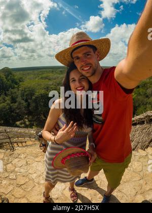 Young traveling couple takes a selfie on top of Mayan pyramid in EkBalam, Mexico. Stock Photo