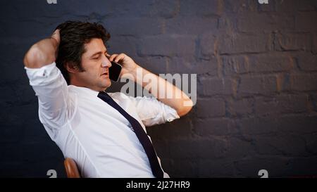 Always available to his clients. Cropped shot of a businessman talking on his cellphone in the office. Stock Photo