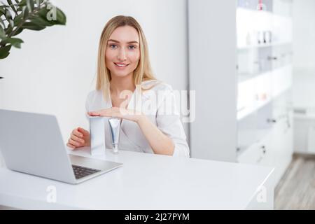 Cheerful woman beautician using laptop in beauty salon Stock Photo