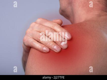 Shoulder pain close up. Abstarct man suffering from ache in body. Red point. High quality photo Stock Photo