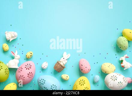 Easter composition. Easter eggs and easter bunny on pastel blue background. Minimal concept of Easter. Flat lay, top view, copy space Stock Photo