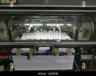 Blurred image of a modern four colour printing machine running in high speed. Shot at Kolkata, West Bengal, India. Stock Photo