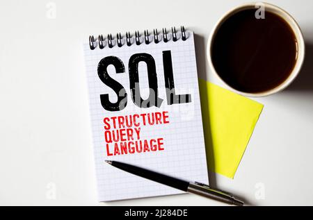 Top view of keyboard,trash paper,clipboard,pen and paper written with SQL. Stock Photo