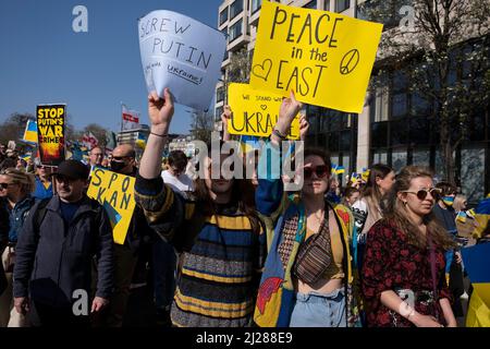 Thousands of people gather in the capital for a peace march ‘London stands with Ukraine’ in solidarity with the people of Ukraine on 26th March 2022 in London, United Kingdom. The conflict in Ukraine is now in it’s second month and their president has called for people across the World to unite in protest at the Russian invasion and ongoing war in the region. The Ukrainian flag of yellow and blue was everywhere to be seen in this colourful show of unity. Stock Photo