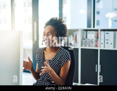 Let me talk you step by step through the process.... Cropped shot of a support agent working in a modern office. Stock Photo
