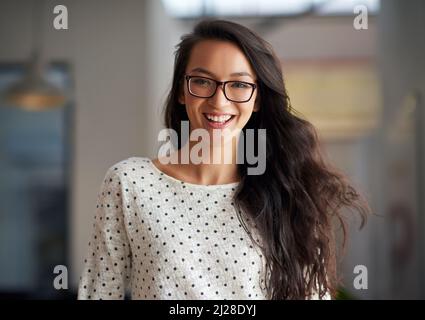 Youthful energy for a new generation. Portrait of a trendy young woman smiling in an industrial style office space. Stock Photo