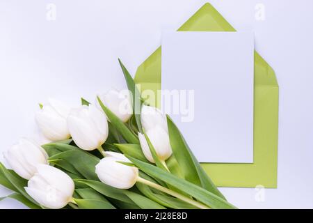 Greeting card template in an envelope with tulips bouquet . Spring holiday concept. Stock Photo
