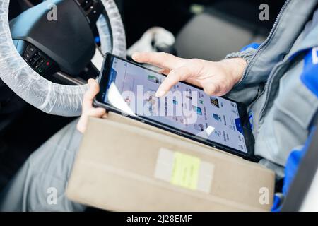 Male engineer makes computer diagnostics of the car in auto service. Stock Photo