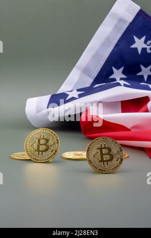 U.S. flag and next to it some bitcoins, on a green table. Stock Photo