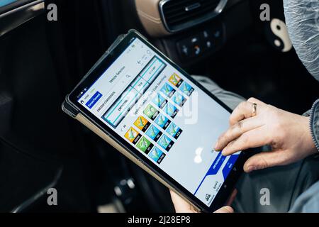 Male engineer makes computer diagnostics of the car in auto service. Stock Photo