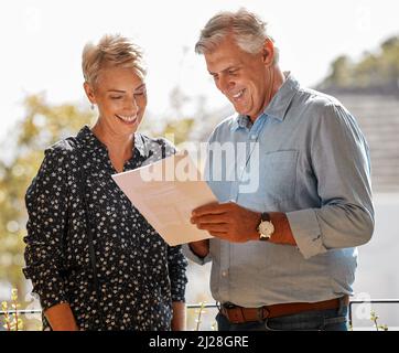 You just have to sign it. Shot of a senior male realtor going through paperwork with a client. Stock Photo