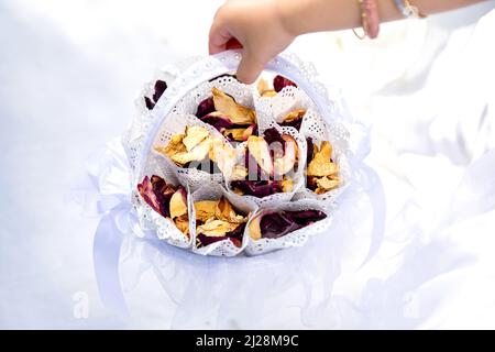 Rose Petal confetti in white basket in the hand of small flower girl Stock Photo