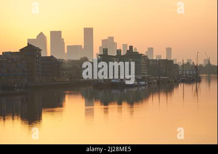 Golden sunrise over the River Thames and with Canary Wharf on the skyline, London England UK Stock Photo