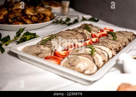 Roasted meat cold cut slices on a white platter Stock Photo