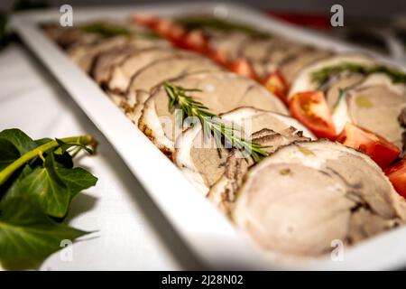 Roasted meat cold cut slices on a white platter Stock Photo