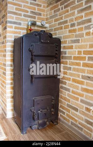Heating the house with wood and coal. Large black cast iron boiler for home  heating. The boiler runs on solid fuel. A fallback option for home heating  Stock Photo - Alamy