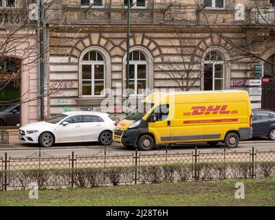 DHL package delivery service truck, van, vehicle parked on the street near a building, DHL German logistics courier company, urban area, Krakow, Polan Stock Photo